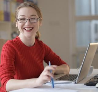 woman smiling looking up from her computer