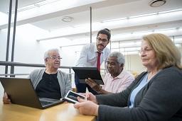 group of people in suits working collaboratively with laptops