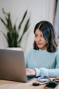 content young woman working at a laptop