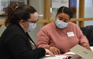 Two women studying course materials