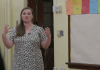 screenshot of video: female teacher in front of class